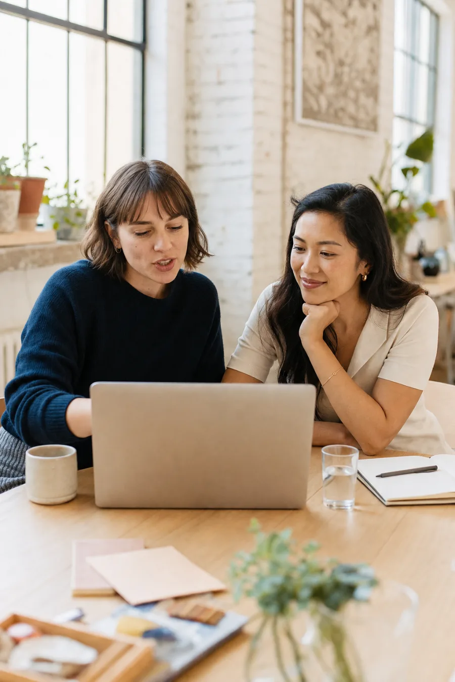 Two colleagues looking at one laptop together