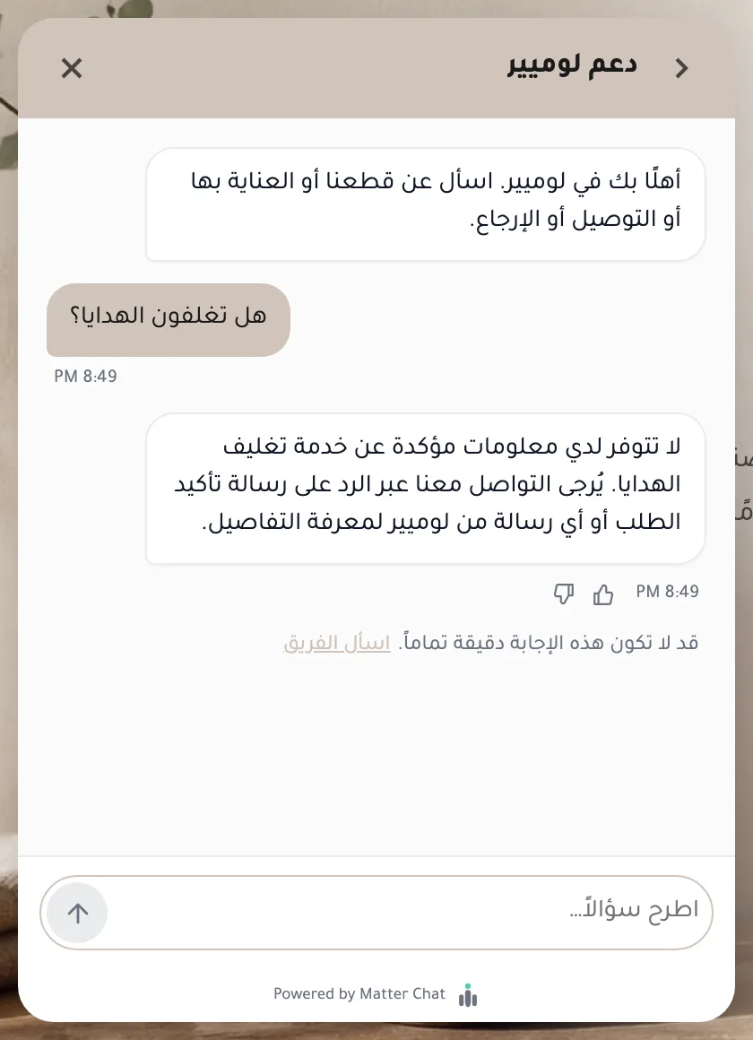 The Arabic assistant, asked “هل تغلفون الهدايا؟” (Do you gift wrap?), replying that it has no confirmed information about gift wrapping and suggesting the visitor reply to their order confirmation to ask, with a note underneath that the answer may not be fully accurate and a link to ask the team.